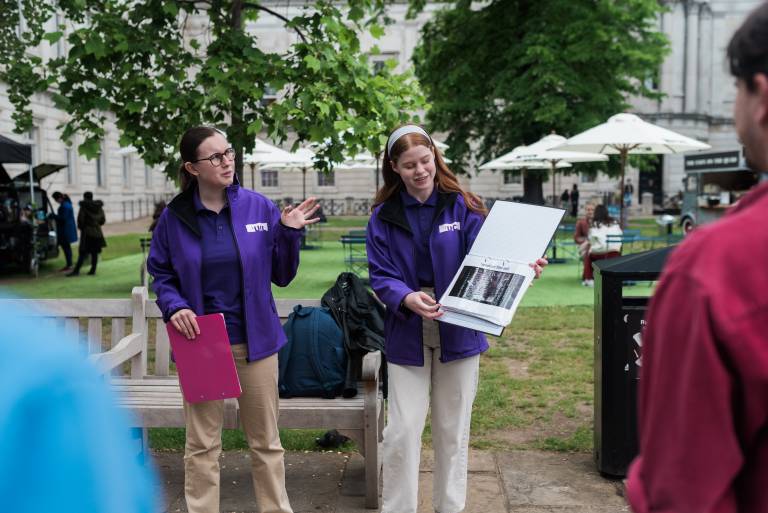 Two tour guides delivering material to the С̳ Walking Tour attendees